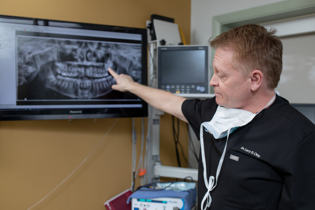 Dr Otte an oral surgeon at Associated Oral and Maxillofacial Surgeons looking at xrays