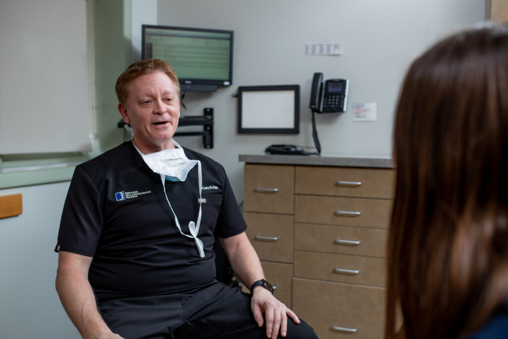 Dr Otte an oral surgeon at Associated Oral and Maxillofacial Surgeons speaking with a patient.