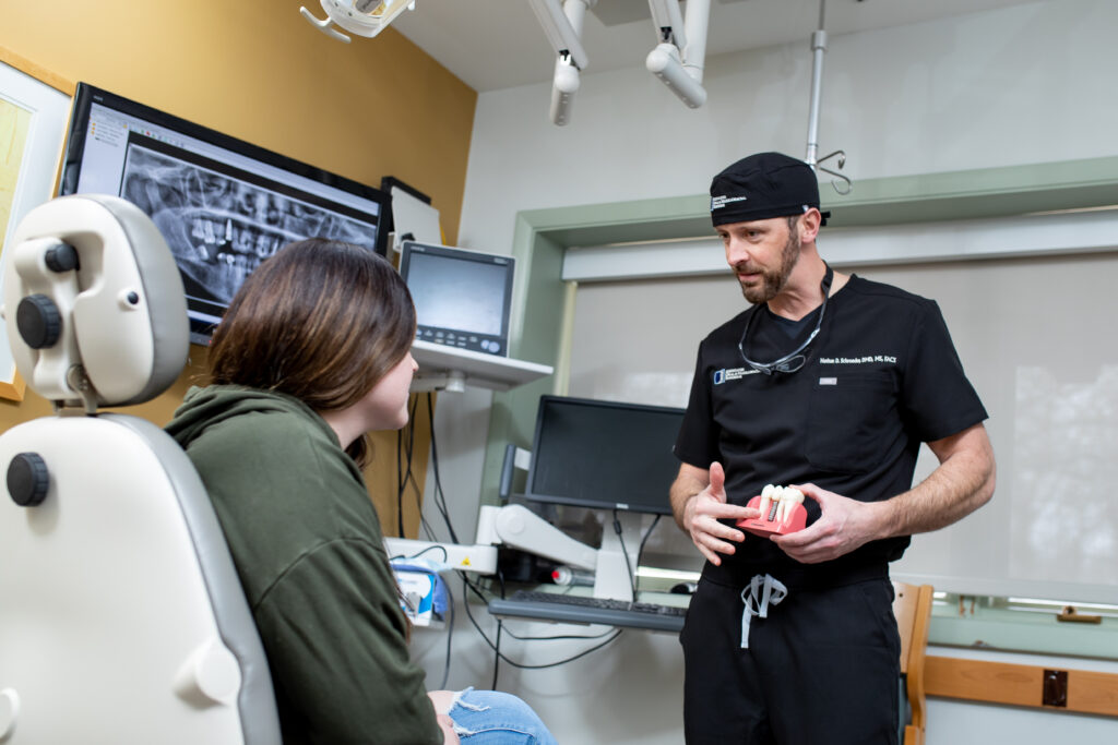 Dr Schroeder an oral surgeon at Associated Oral and Maxillofacial Surgeons talking with a patient