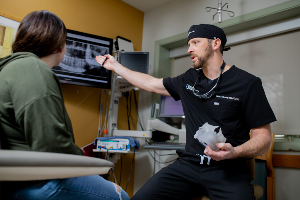 Dr Schroeder an oral surgeon at Associated Oral and Maxillofacial Surgeons speaking with a patient