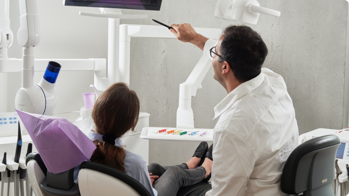 An oral surgeon helping a patient after an oral surgery procedure